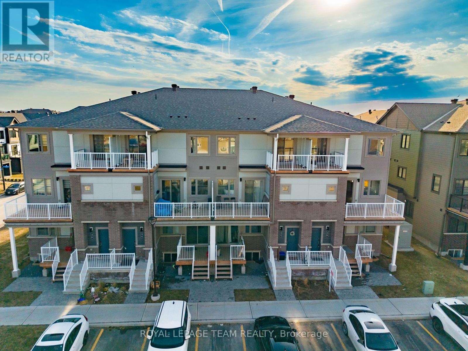 A sunny day at a Royal Leage Team Realty property with cars parked in the driveway.