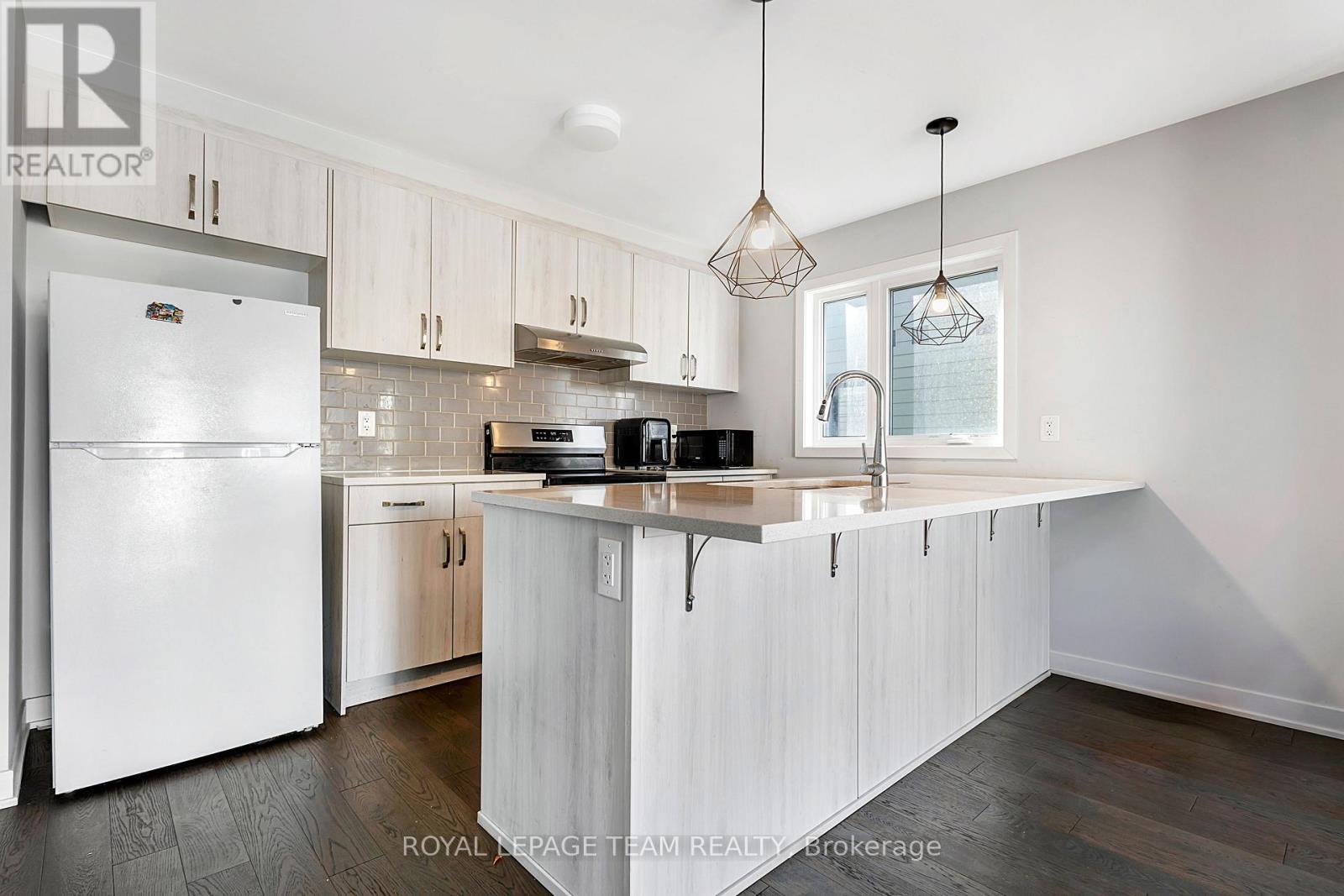 A kitchen with white cabinets and a white refrigerator.