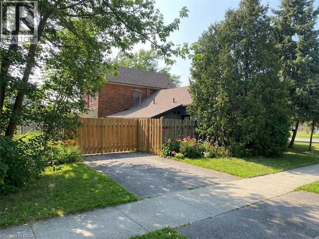 A house with a brown fence and green trees in front.