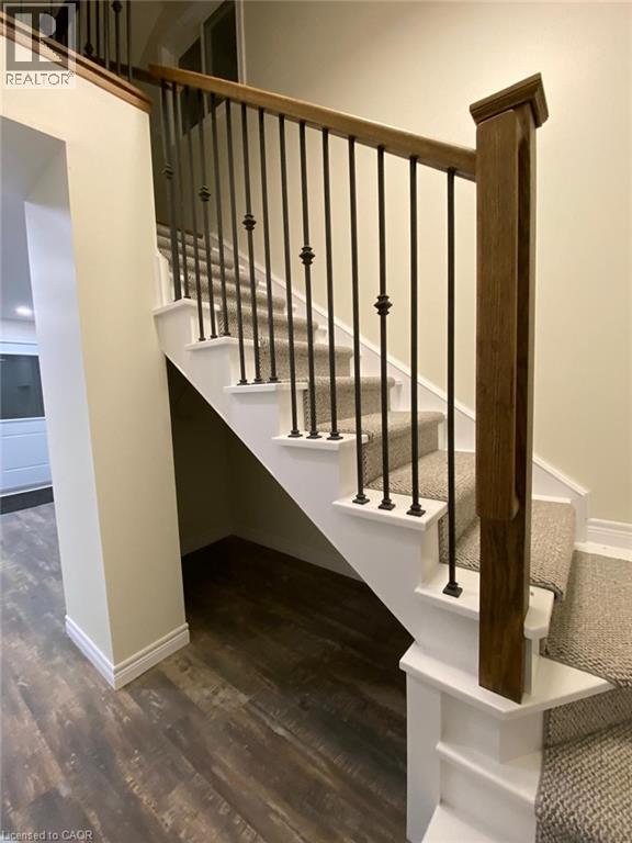 A staircase with a wooden handrail and white risers.