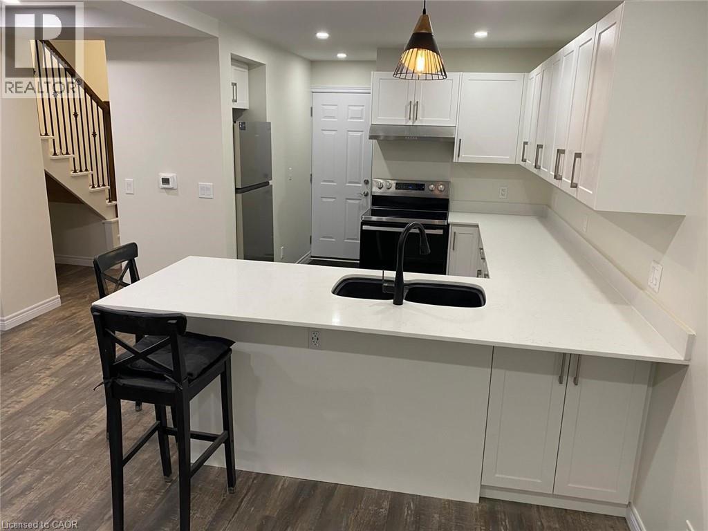 A kitchen with a white countertop and black bar stools.