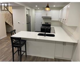 A kitchen with a white countertop and black bar stools.