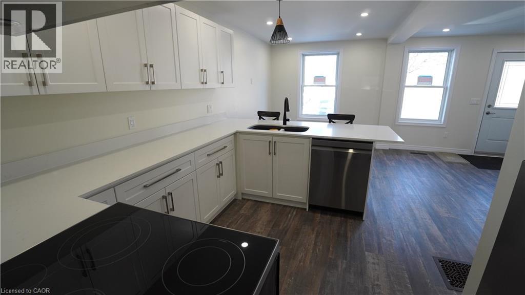 A modern kitchen with a stove top oven and a refrigerator.