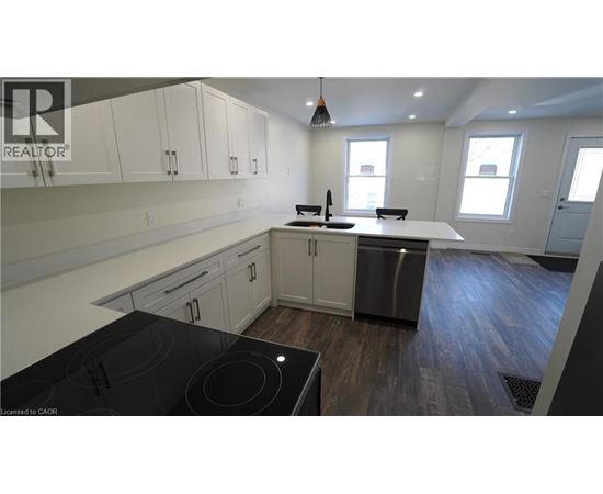 A modern kitchen with a stove top oven and a refrigerator.