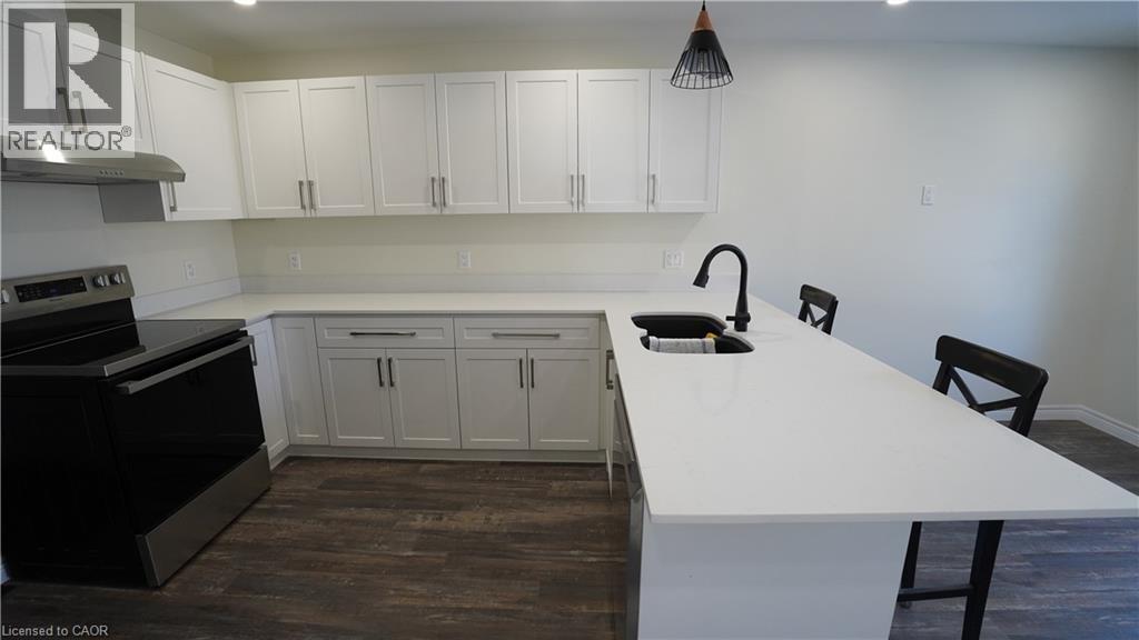 A kitchen with white countertops and black appliances.