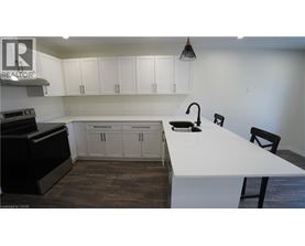 A kitchen with white countertops and black appliances.