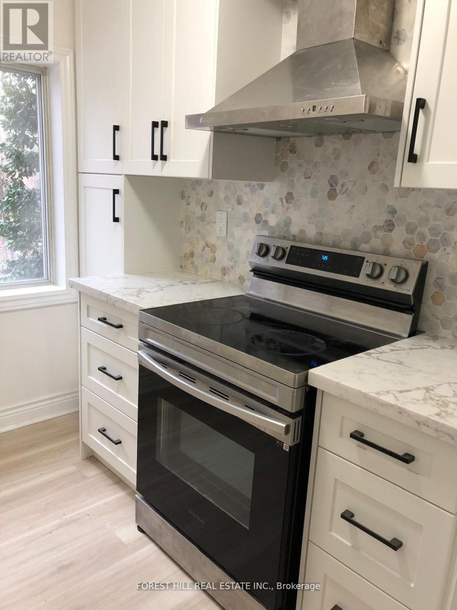 A kitchen with a black stove top oven and white cabinets.