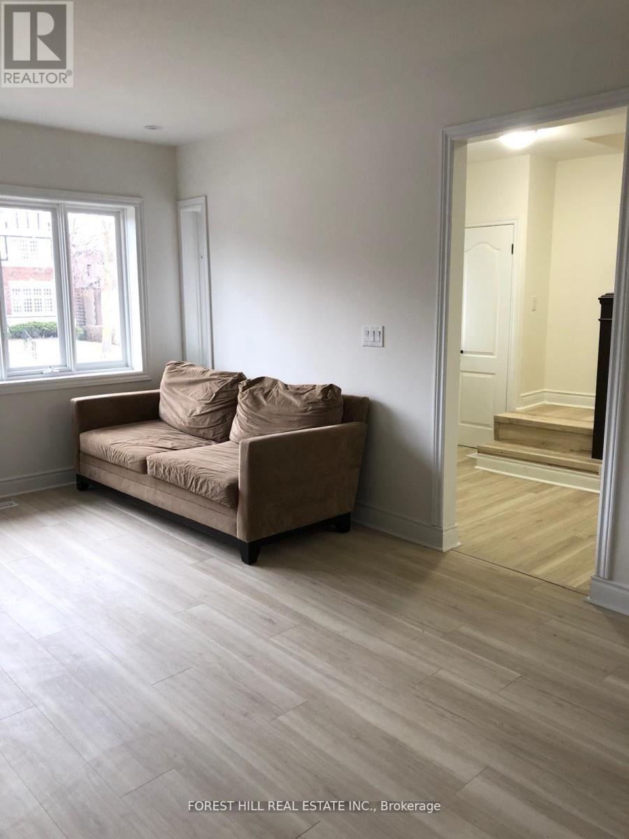 A living room with a couch and a doorway leading to another room.