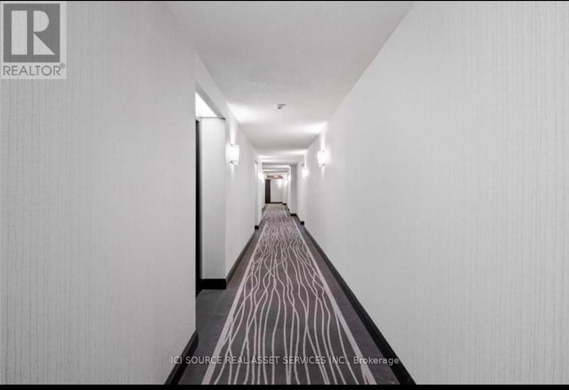 A long hallway with a wooden floor and white walls.
