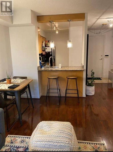 A kitchen with a table and chairs in the foreground and a bar area in the background.