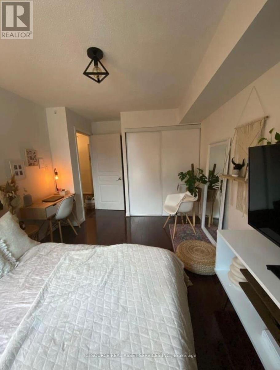 A bedroom with a large bed and a television.