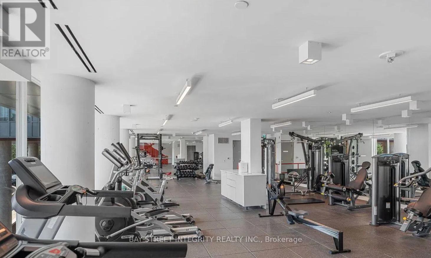 A gym with a variety of equipment including treadmills, weights, and exercise machines.