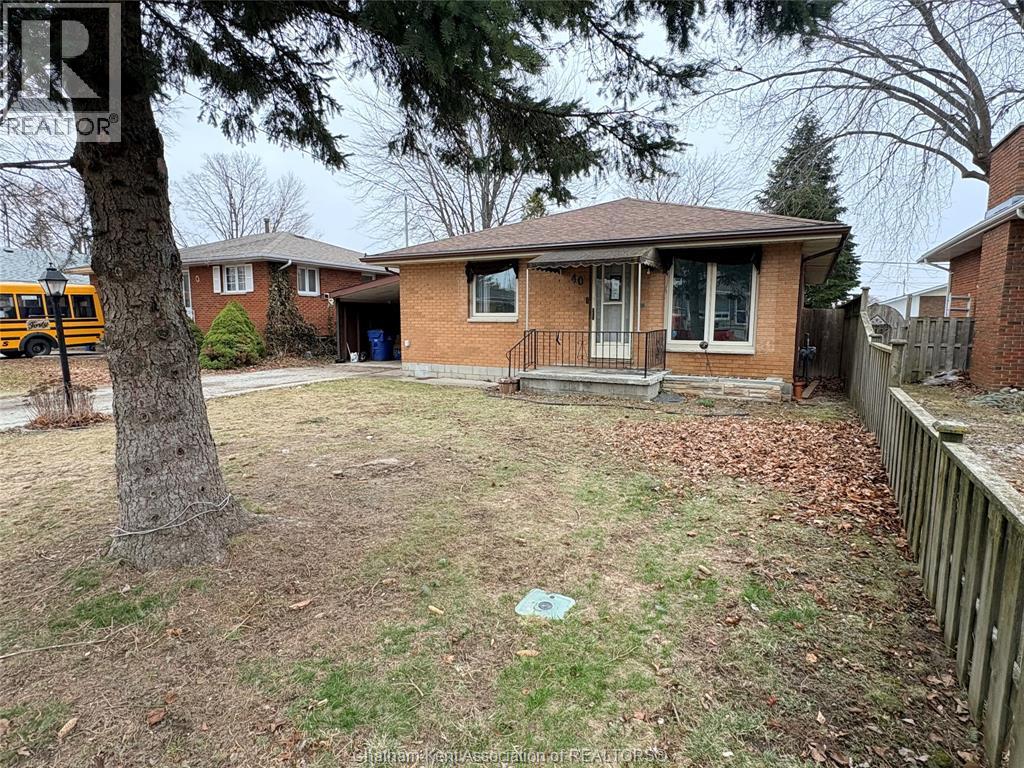 A house with a brown roof and a tree in front of it.
