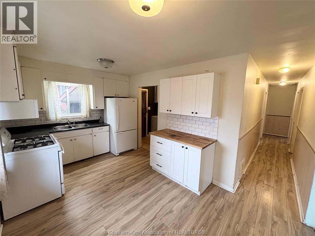 A kitchen with white appliances and cabinets.