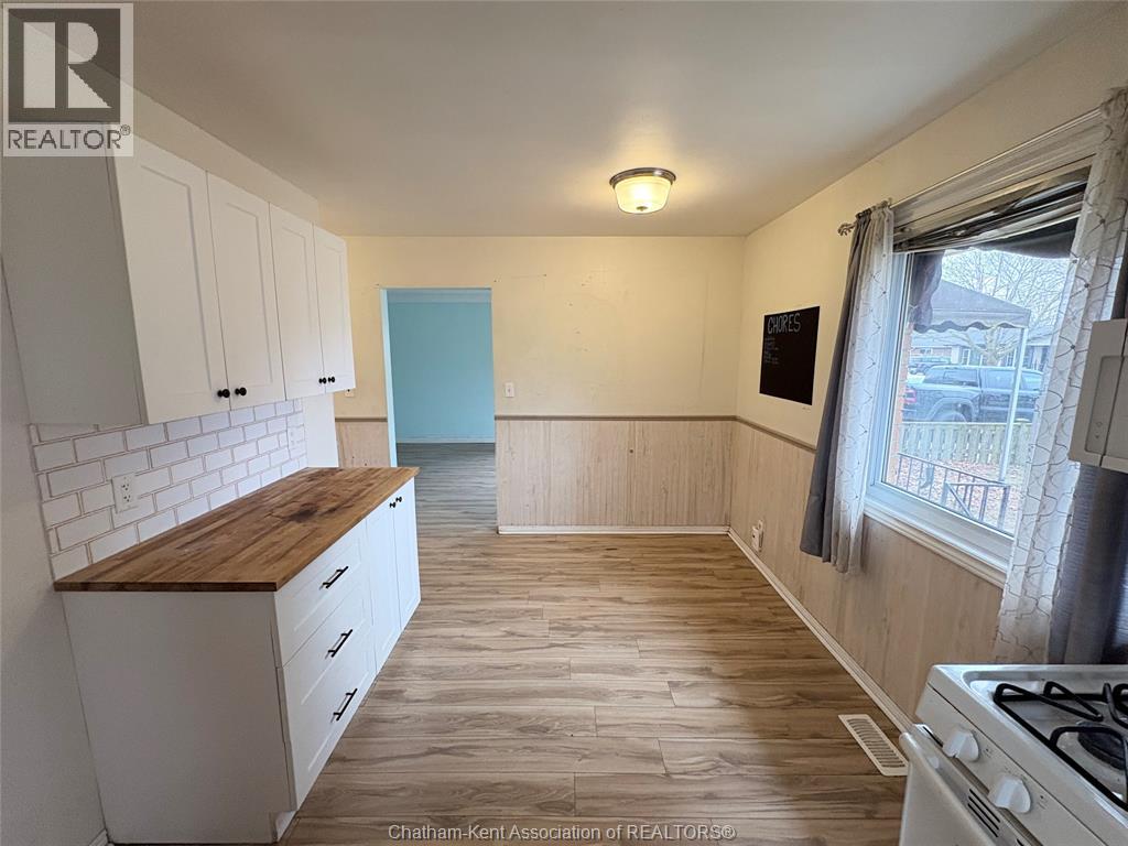 A kitchen with white cabinets and a wooden countertop.