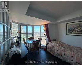 A bedroom with a bed, table, chairs and a view of the city.