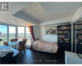 A bedroom with a bed covered in a blanket that has a pattern of money on it.