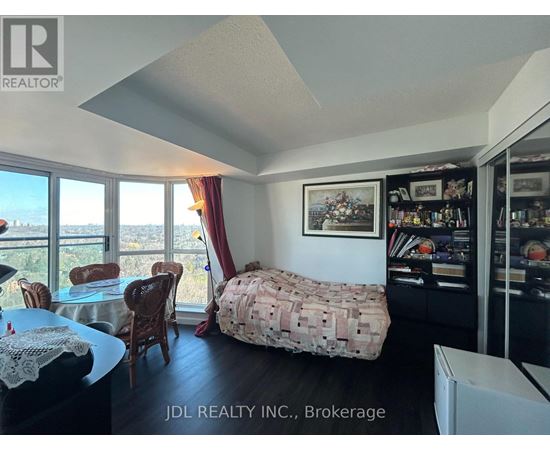 A bedroom with a bed covered in a blanket that has a pattern of money on it.