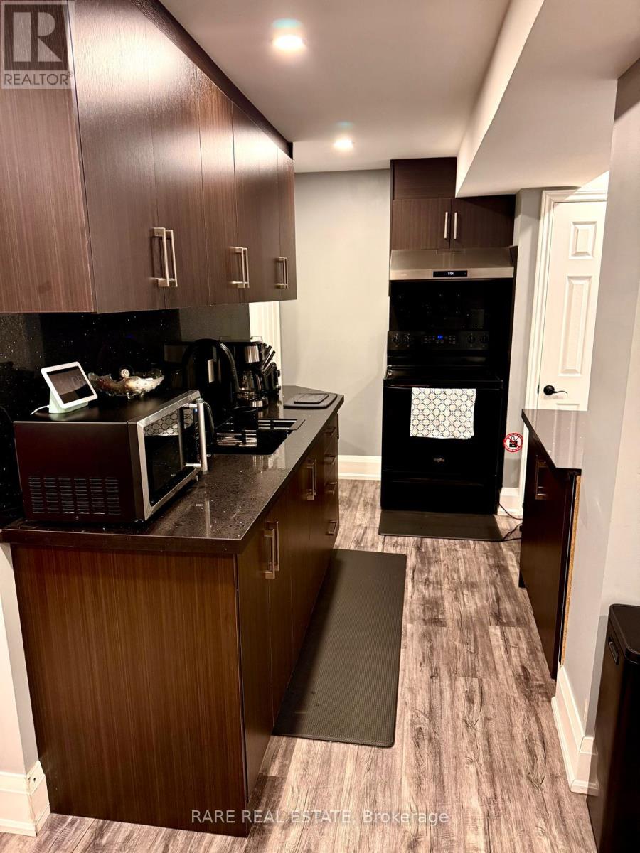 A kitchen with a black oven and microwave.