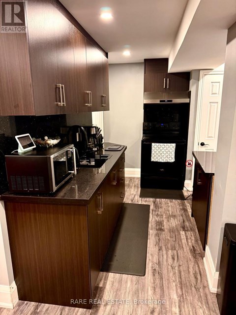 A kitchen with a black oven and microwave.