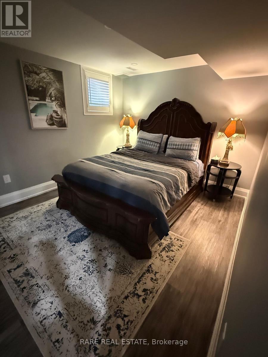 A bedroom with a bed, two lamps, and a rug.
