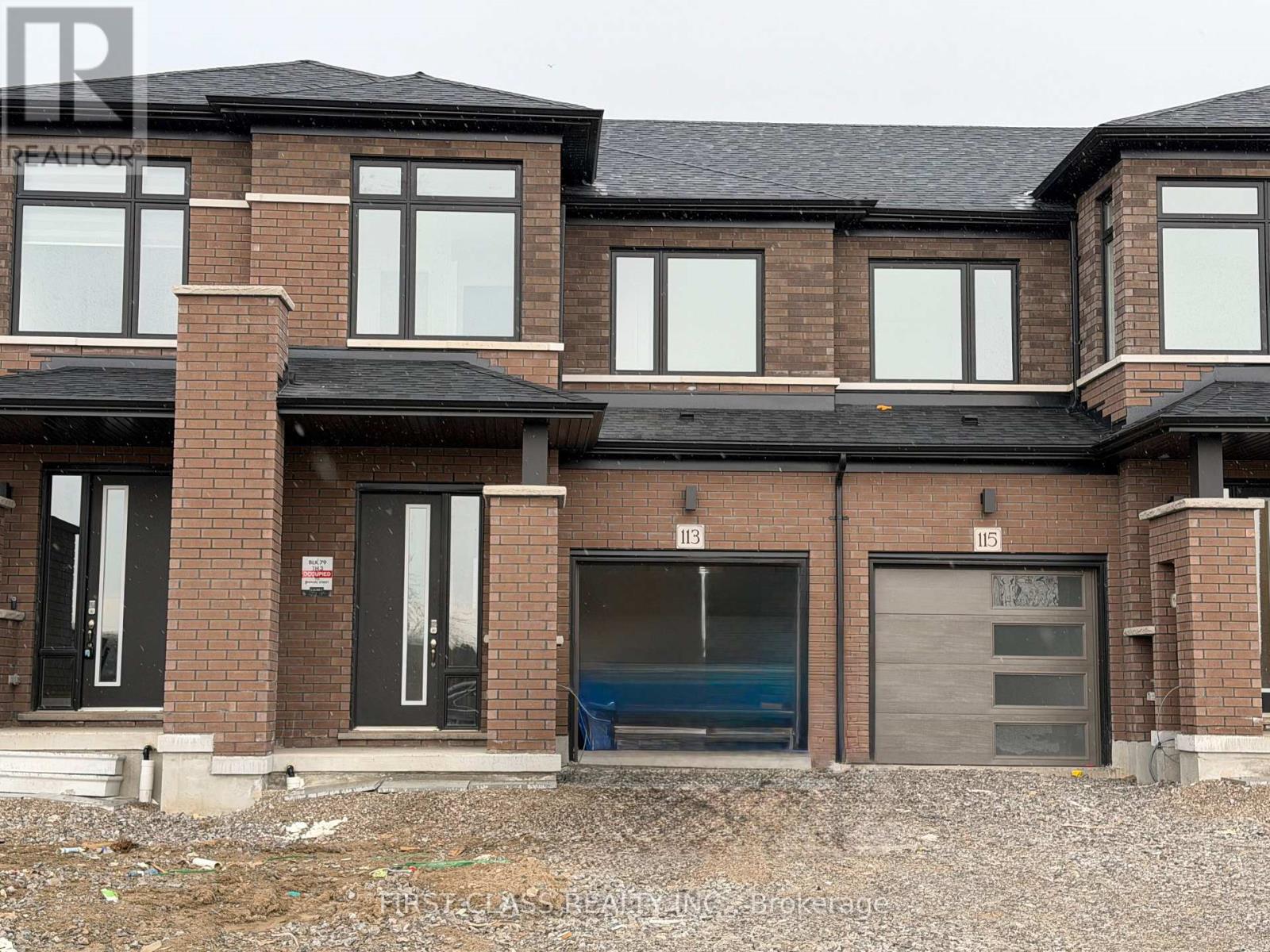A large, multi-story residential building with a brick facade and multiple garage doors.