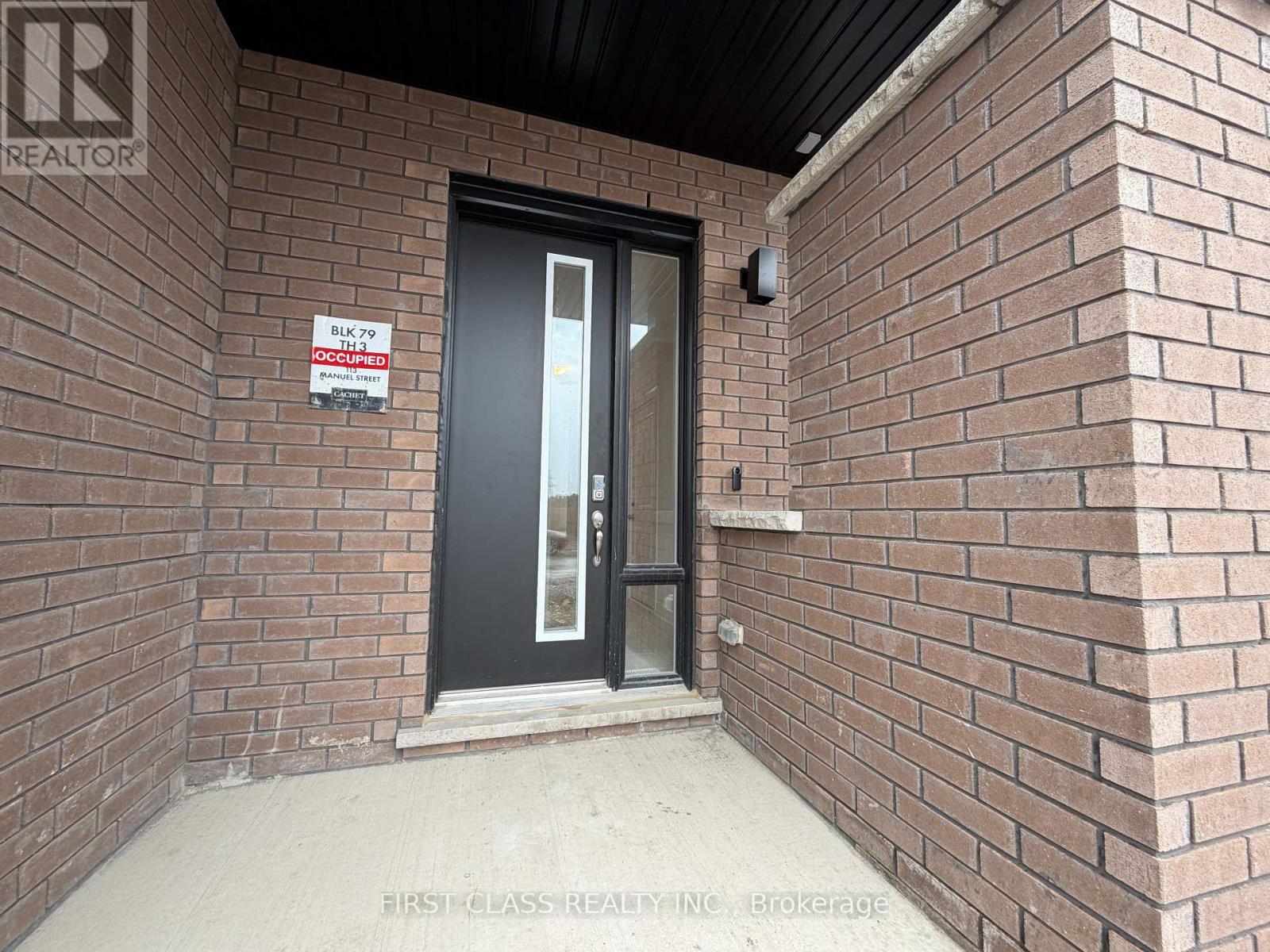 A brick wall with a black door and a sign that says "BLACK 79".