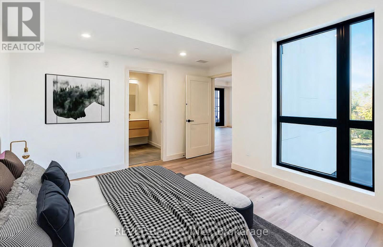 A bedroom with a large bed and a painting on the wall.