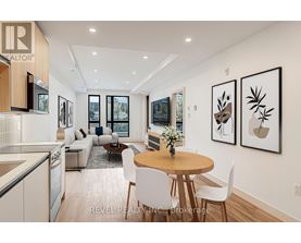A modern dining room with a round table and chairs.