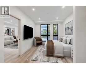 A bedroom with a large bed and a flat screen TV mounted on the wall.