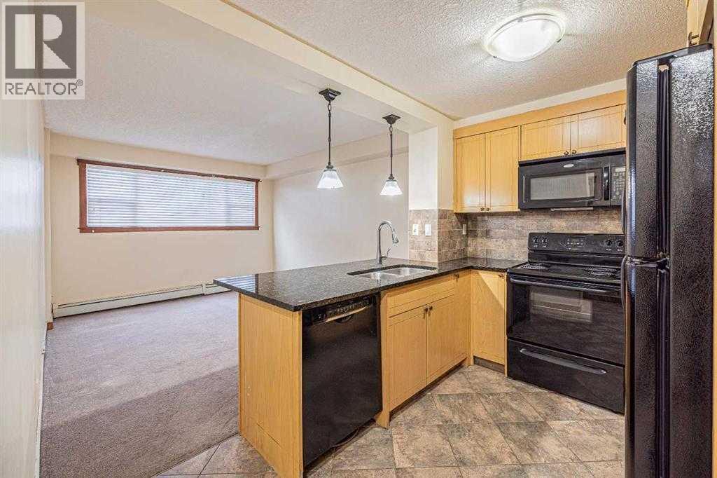 A kitchen with black appliances and wooden cabinets.