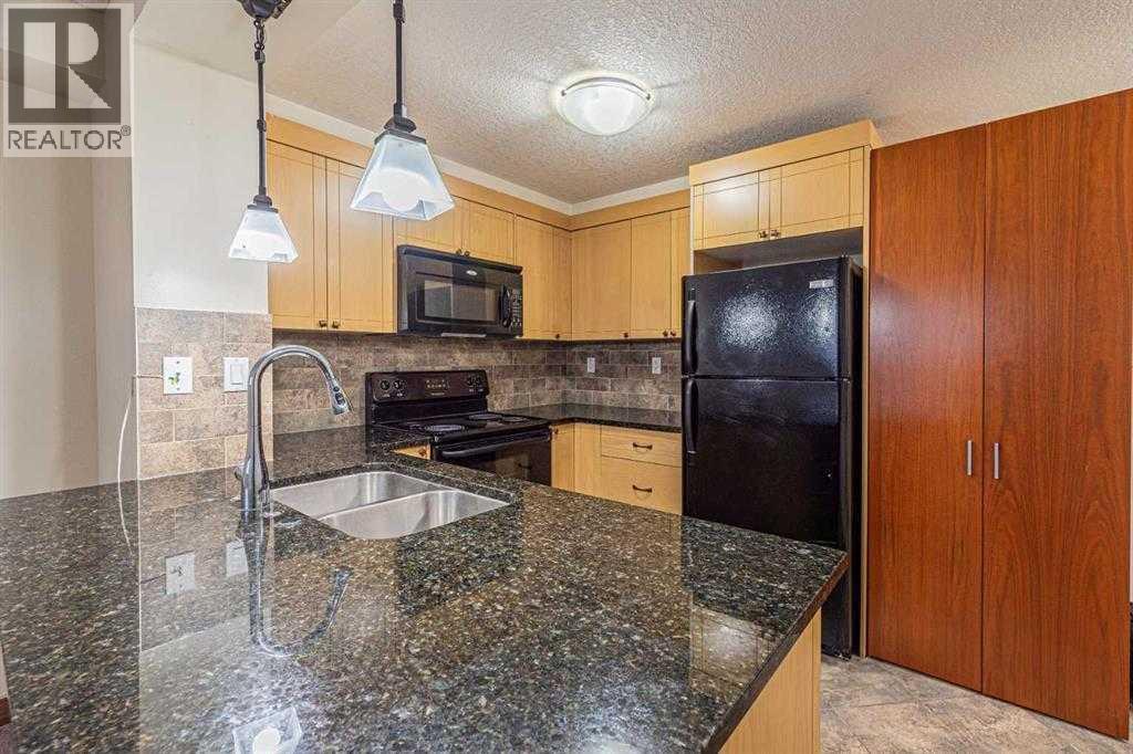 A kitchen with granite countertops and wooden cabinets.