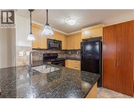A kitchen with granite countertops and wooden cabinets.