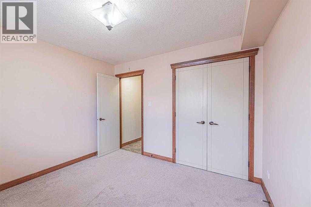 A bedroom with a white door and a white wardrobe.