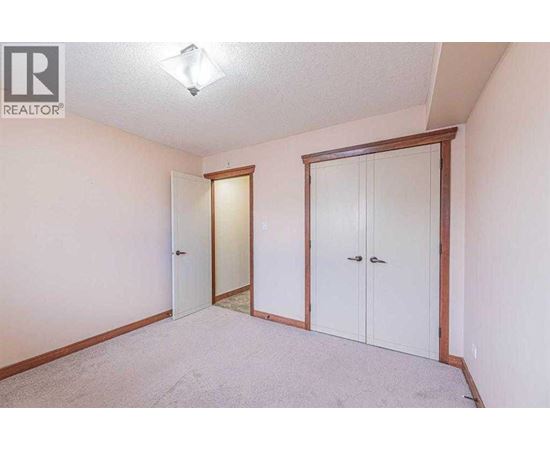 A bedroom with a white door and a white wardrobe.
