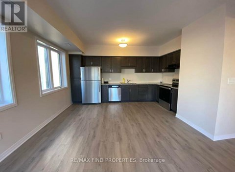 A kitchen with a refrigerator, oven, and sink.