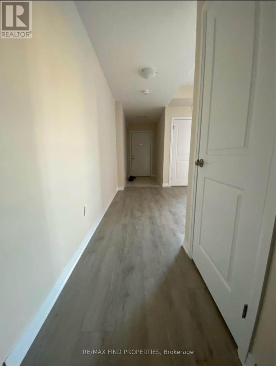 A hallway with a white door and a white wall.