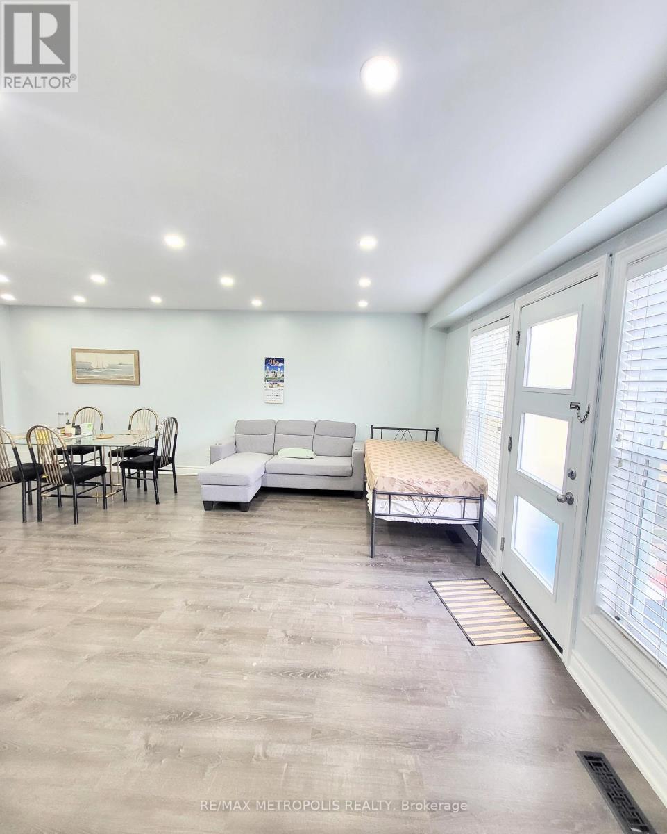 A living room with a couch, chairs, and a table.