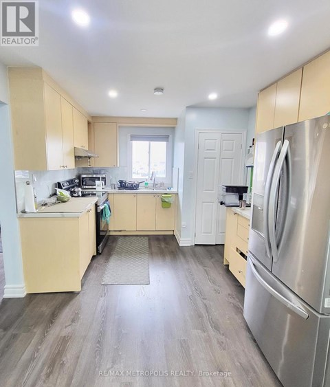 A kitchen with wooden cabinets and a stainless steel refrigerator.