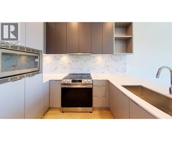 A modern kitchen with a stove top oven and a sink.