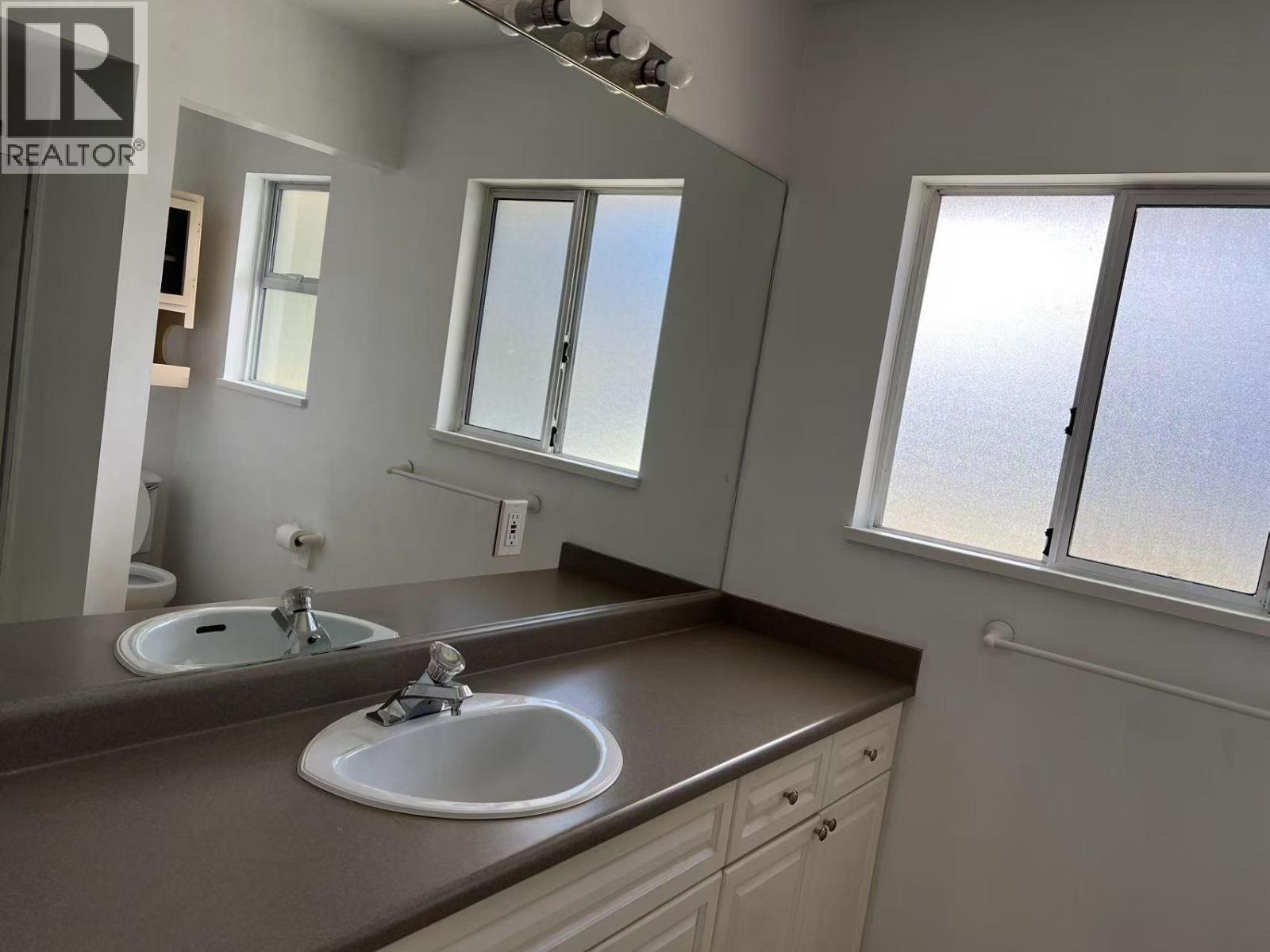 A bathroom with two sinks and a large mirror.