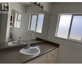A bathroom with two sinks and a large mirror.
