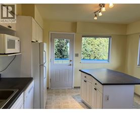 A kitchen with a black countertop and white cabinets.