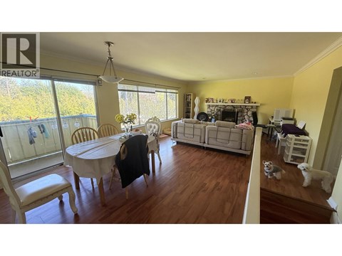 A living room with a dining table and chairs.