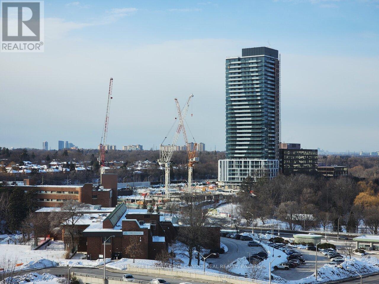 A cityscape with a large building under construction in the foreground.