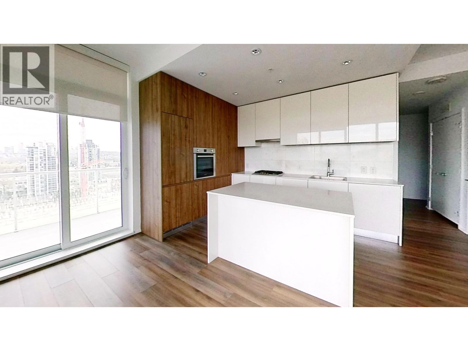 A modern kitchen with white countertops and wooden cabinets.
