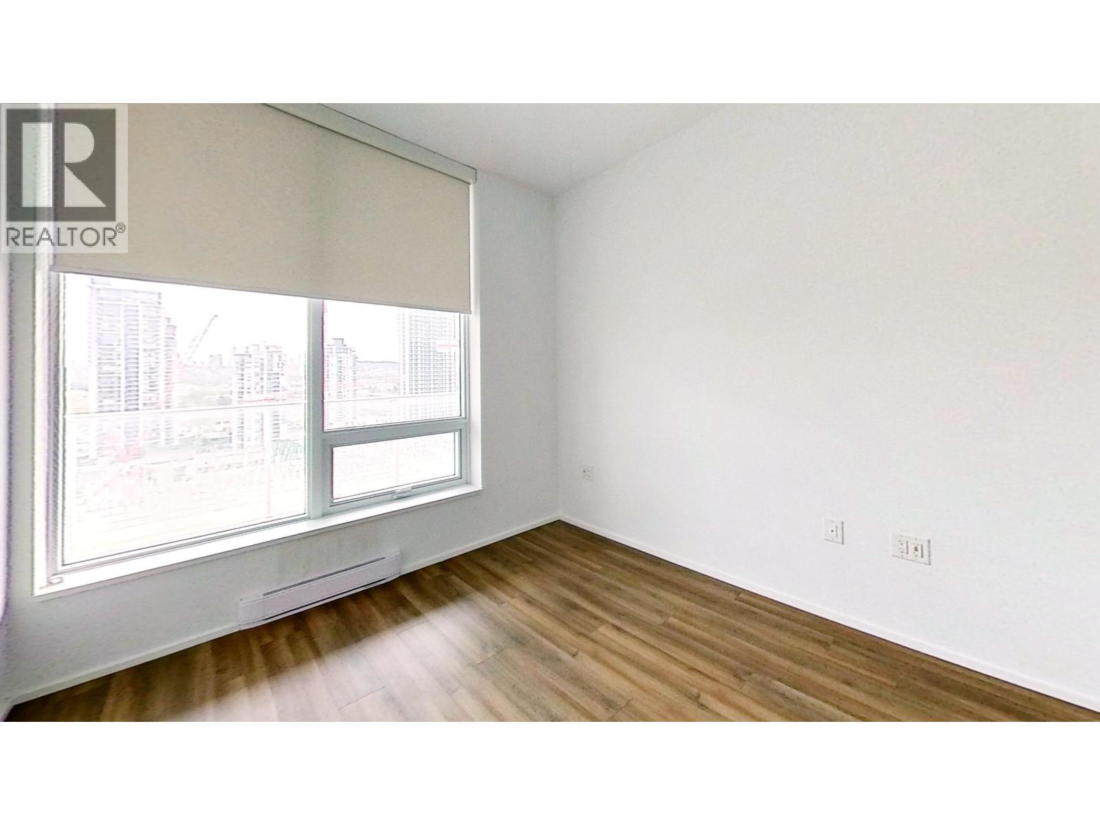 A room with a window and wooden floors.