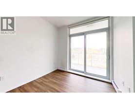 A room with a large window and wooden flooring.