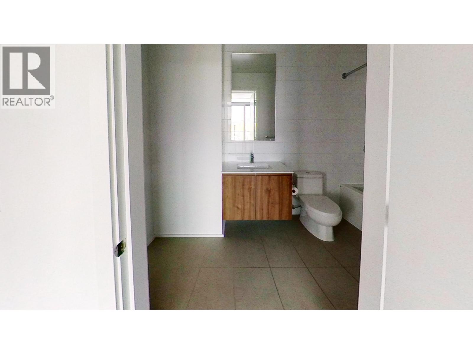A bathroom with a toilet, sink and mirror.