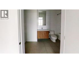 A bathroom with a toilet, sink and mirror.